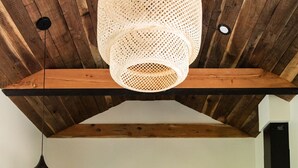Een moderne keuken met donkere kastjes, een ronde houten tafel en een hangende lamp.