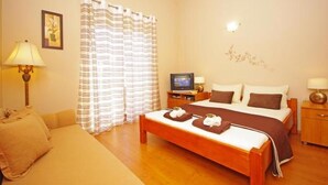 A hotel room with a bed, a TV, a desk, a lamp, and a sofa. - Apartment in Zaton (Zadar) with Seaview, Loggia, Air condition, WIFI (4810-4) (Zaton)