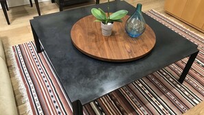 A modern dining table with a wooden center and a black top, surrounded by a patterned rug. -  Guest house, Historical Area, Close to Beverly Hills,  and Studios (Los Angeles)