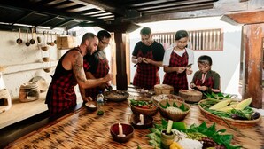 A rustic kitchen with wooden beams, hanging utensils, and a variety of fresh ingredients on the counter. - BAKUNGAN diJero Homestay (Mengwi)