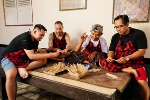 Un grupo de personas sentadas alrededor de una mesa de madera con brochetas de comida.