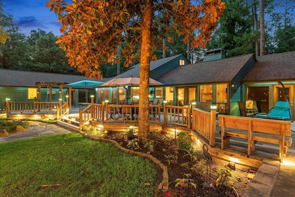 The deck is beautifully illuminated with soft lighting, from fixtures in the trees to lights beneath the deck. This gentle glow creates a magical ambiance, making it easy to see and move around while maintaining a relaxing, cozy atmosphere for evenings out