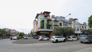 A street with parked cars and buildings with balconies. - Ratana Cengkareng (Jakarta)