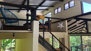 Un intérieur à plusieurs niveaux, avec un escalier, un hamac et une décoration en forme d’étoile.