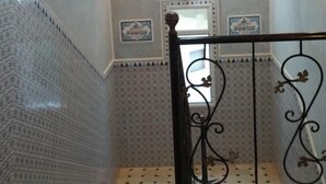 Eine Treppe mit gemusterten Fliesen und einem Metallgeländer.