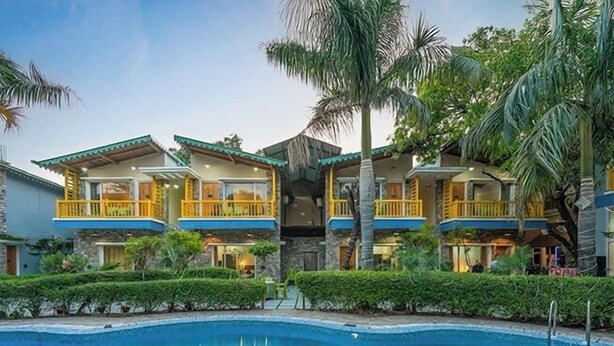 A hotel with a swimming pool, multiple balconies, and lush greenery. - Delight Stay Resort Dhikuli - Corbett (Ramnagar)