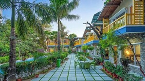 A courtyard with a tiled floor, potted plants, and outdoor seating. - Delight Stay Resort Dhikuli - Corbett (Ramnagar)
