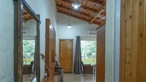 A hallway with a wooden ceiling, a mirror, a wooden bench, and a door leading to a room. - Delight Stay Resort Dhikuli - Corbett (Ramnagar)
