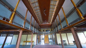 A spacious interior with a central staircase, high ceilings, and large windows. - Havana Club Resort (Trincomalee)