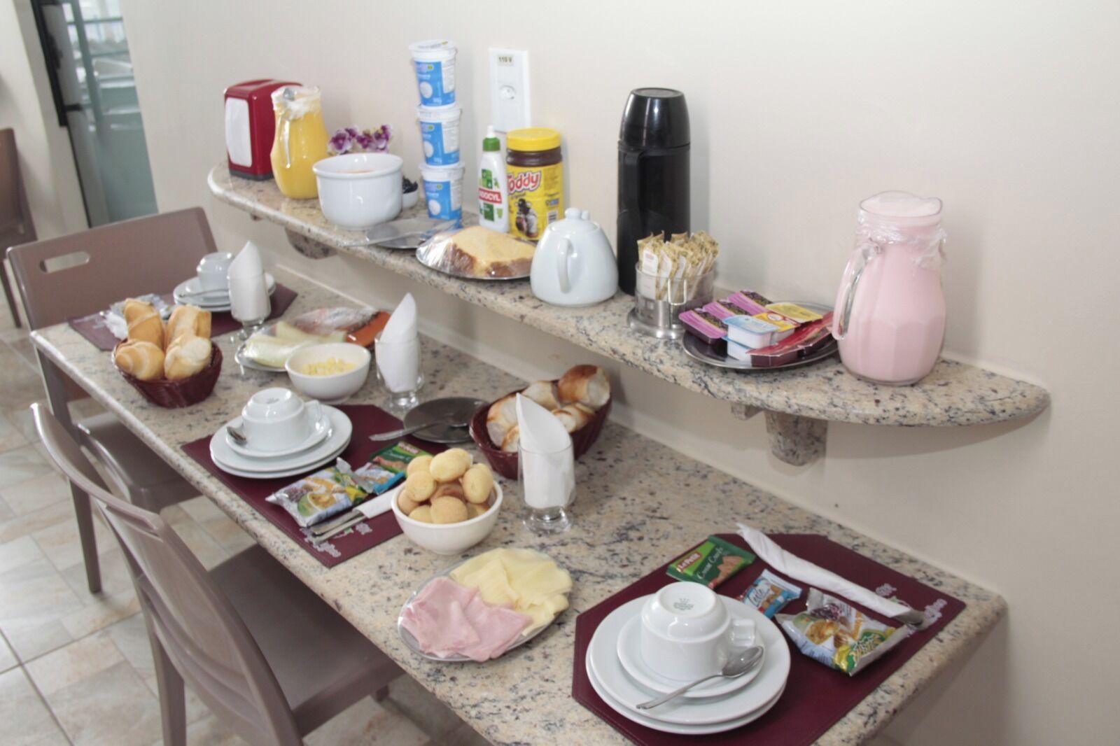 A breakfast setup with bread, eggs, and beverages on a kitchen counter.