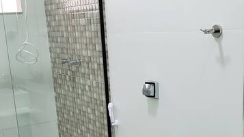 A modern bathroom with a glass-enclosed shower, a toilet, and a bathtub.