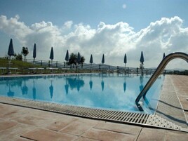 Una piscina al aire libre, sombrillas