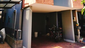 Un edifici modern de dos pisos amb un vestíbul cobert i una bicicleta aparcada a l'exterior.