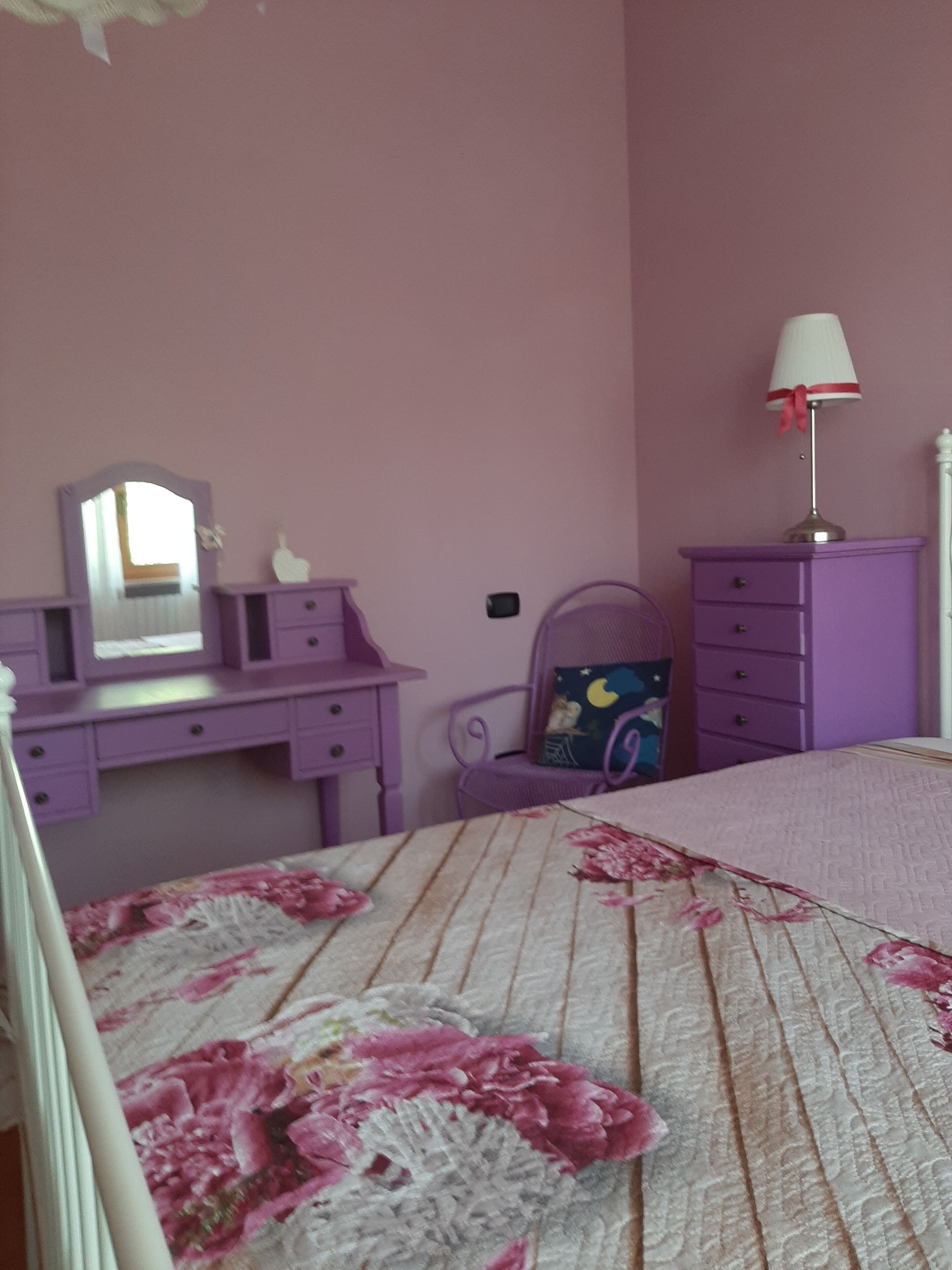 A bedroom with a bed, a dresser, and a chair.