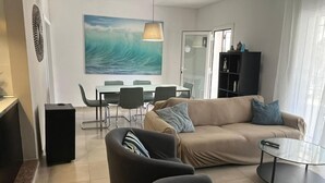 A modern living room with a beige sofa, a glass coffee table, and a dining area with a table and chairs. - villa with private pool, 11 people, air conditioning located 200m from the beach (L' Ametlla de Mar)
