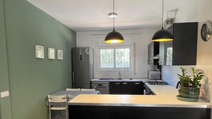 A modern kitchen with a central island, black cabinets, and pendant lighting. - villa with private pool, 11 people, air conditioning located 200m from the beach (L' Ametlla de Mar)