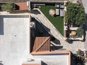 Vista aèria d'una terrassa amb zona de pati, un petit jardí i seients.