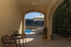 Ein Außenbereich mit Sitzgelegenheiten, einem Pool, einer Pergola und Blick auf einen Berg.