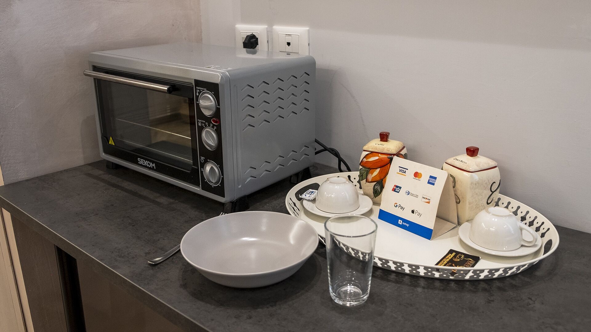 Une petite cuisine équipée d’un four à micro-ondes, d’un grille-pain et d’un service à thé.