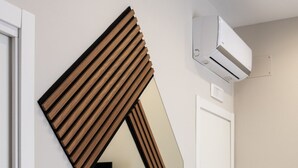 Une pièce dotée d’un grand miroir, d’une porte et d’un appareil de climatisation.