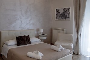 Une chambre d’hôtel avec un lit, une table de chevet, un radiateur et un tableau encadré au mur.