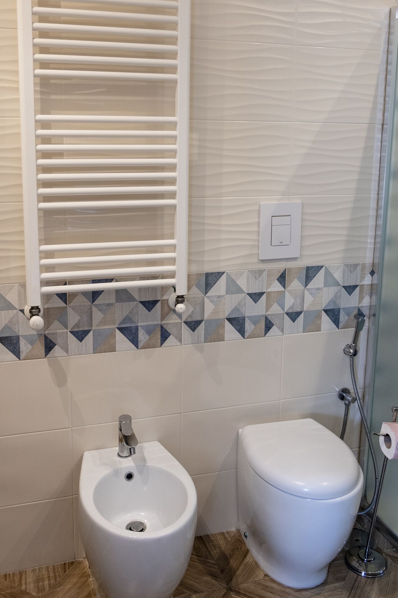 A bathroom with a bidet, toilet, and a shower.