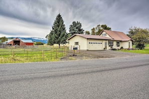A rural property with a large house, a barn, and a fenced pasture.