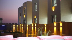 A modern building with multiple windows and a wooden fence. - Al Asala Resort (Al Hadd)