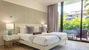 A modern hotel room with a large bed, a nightstand, a lamp, and a view of the outdoors.
