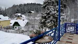 A balcony with a view of a snow-covered village and forest. - Alimar (Predeal)