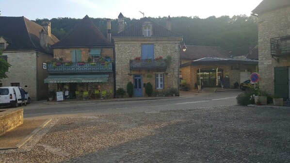 A stone building with a blue door and a balcony with flowers. - Maison de Noëmie near Sarlat, heated swimming pool from mid-May to the end of September (Daglan)