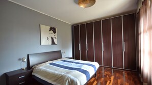 A bedroom with a bed, a nightstand, a wardrobe, and a ceiling light fixture. - Chicco Apartment Light (Vercelli)