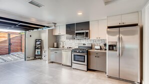 A modern kitchen with stainless steel appliances, a microwave, a toaster, and a refrigerator.