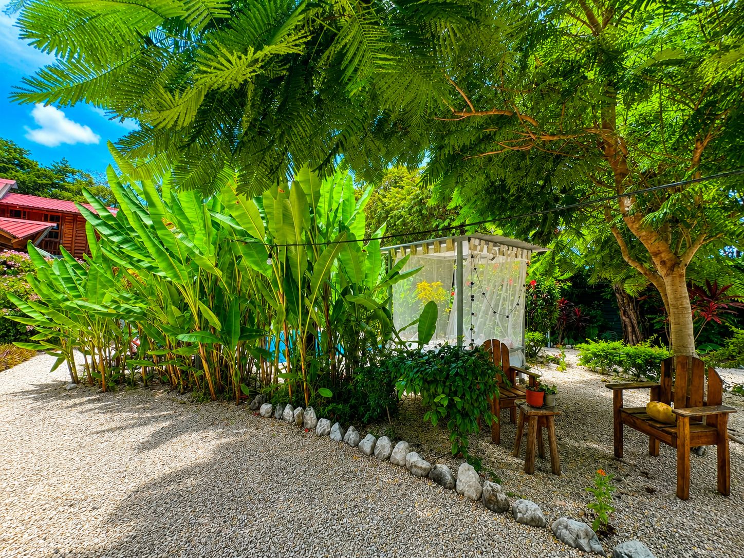 A garden area with a gazebo, seating, and a variety of plants.