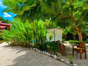 A garden area with a gazebo, seating, and a variety of plants. - Cabañas Lamaite (Sámara)