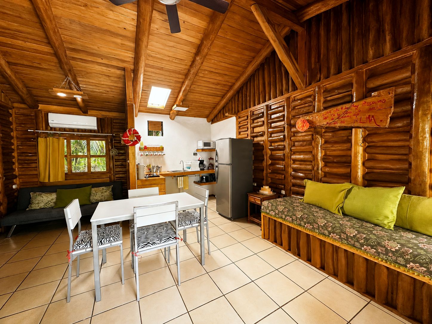 Interior de una cabaña con comedor, cocina y zona de estar.