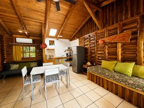 A cabin interior with a dining area, kitchen, and seating area. - Cabañas Lamaite (Sámara)