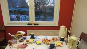 Ruokapöytä on katettu erilaisilla astioilla, aterimilla ja siinä on myös vedenkeitin.