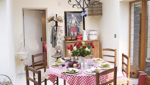 A dining area with a checkered tablecloth, wooden chairs, a chandelier, and a view through a skylight. - Castle Combe - the prettiest Cotswold village near Bath / 6 bedrooms ensuite (Castle Combe)