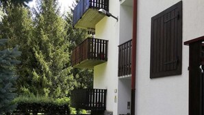 A multi-story building with balconies, stone paving, and a garden with trees and shrubs. - MORGEX 923 _Monte Bianco_Valdigne (Morgex)