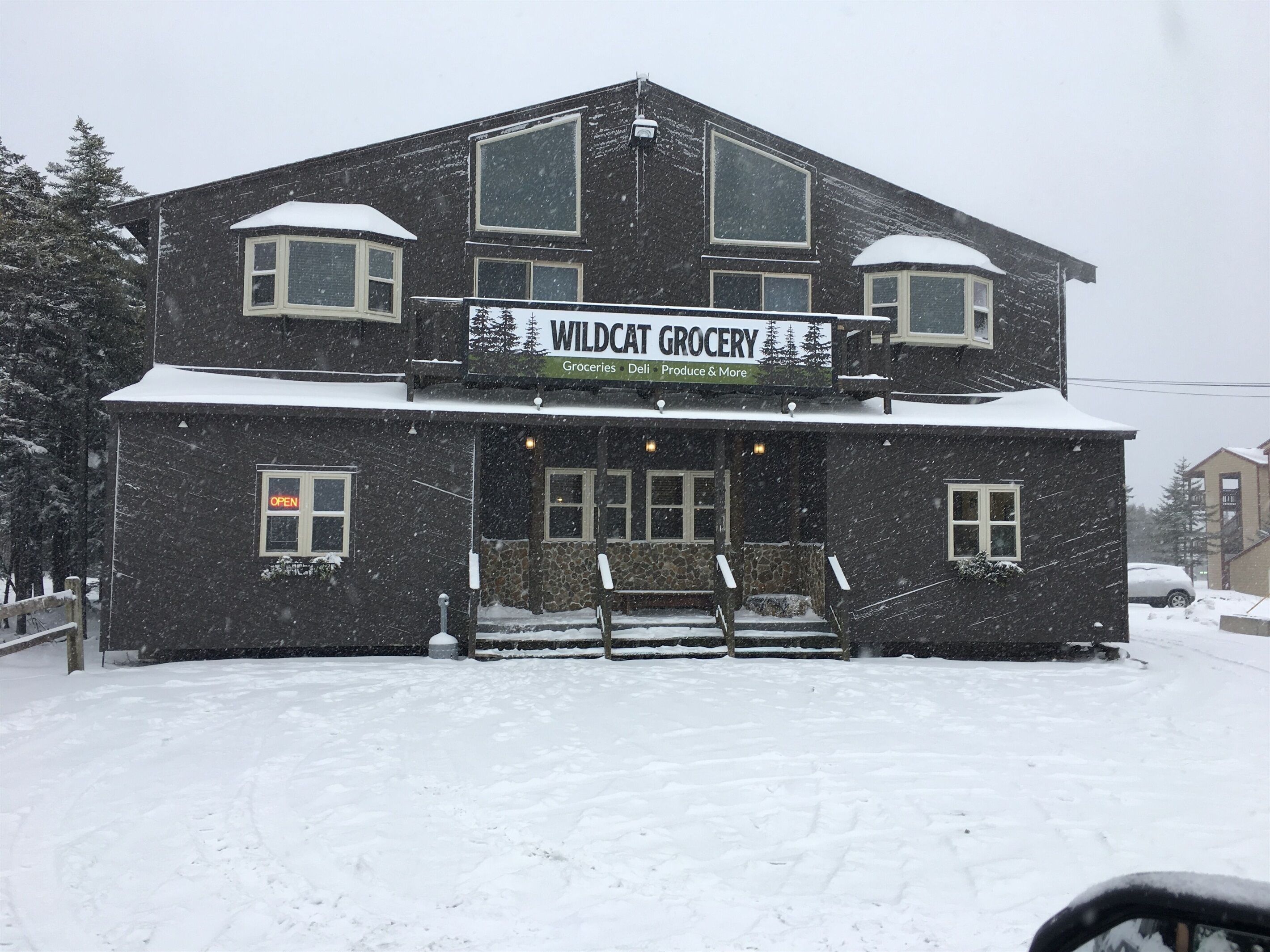 A two-story building with a sign reading "Wildcat Grocery" and a snow-covered ground.