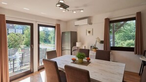Un espace repas moderne avec une grande table, des chaises et des plantes en pot.