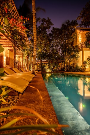 Una piscina al aire libre, sillones reclinables de piscina