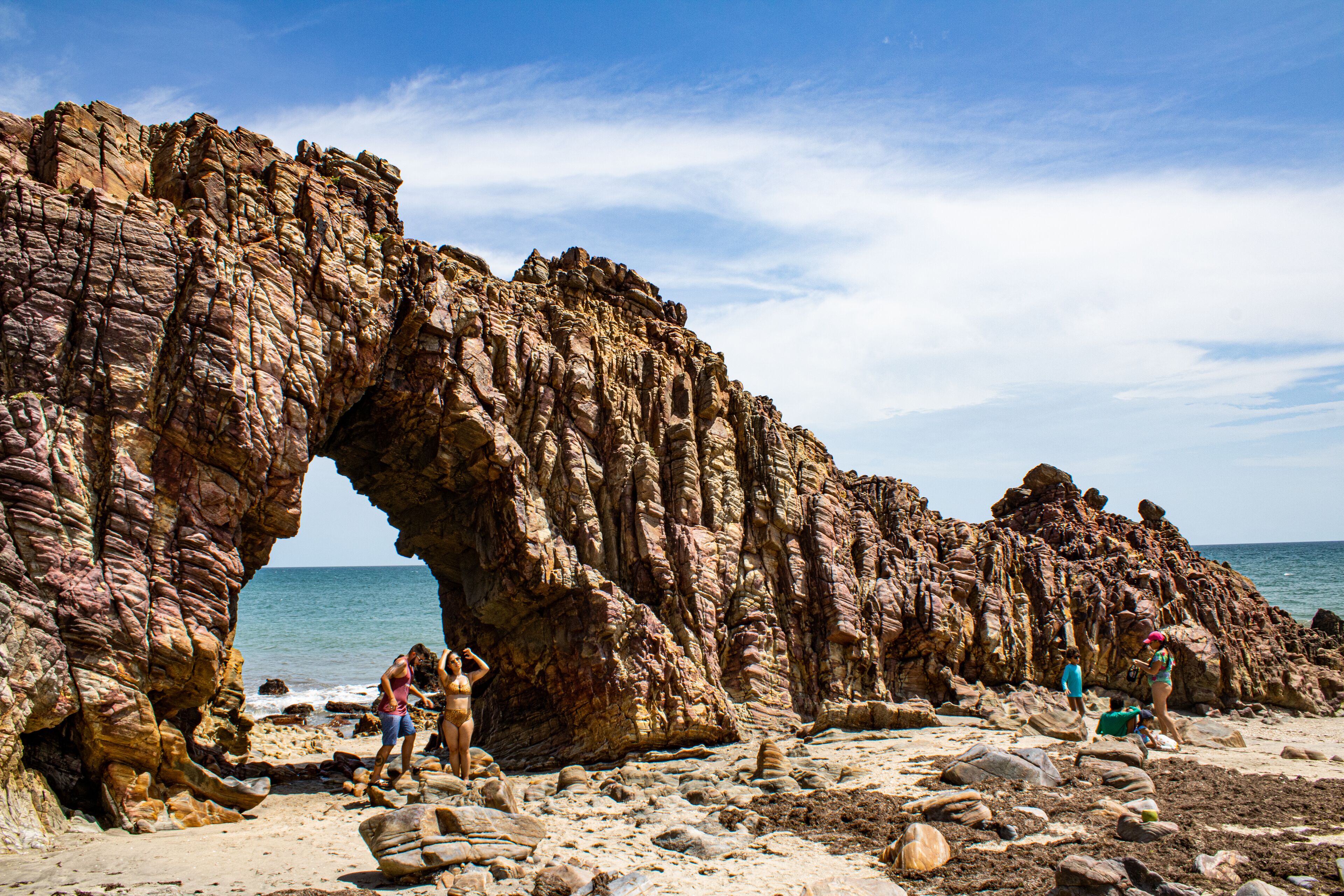 A rocky coastal landscape with a prominent rock arch formation.