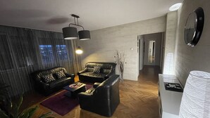 Un salon moderne comprenant un canapé, une table basse et un vase décoratif.