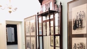 Un corridoio con uno specchio con cornice in legno e quadri appesi al muro.