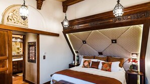 Une chambre avec un grand lit, une tête de lit en bois et deux lampes de chevet.