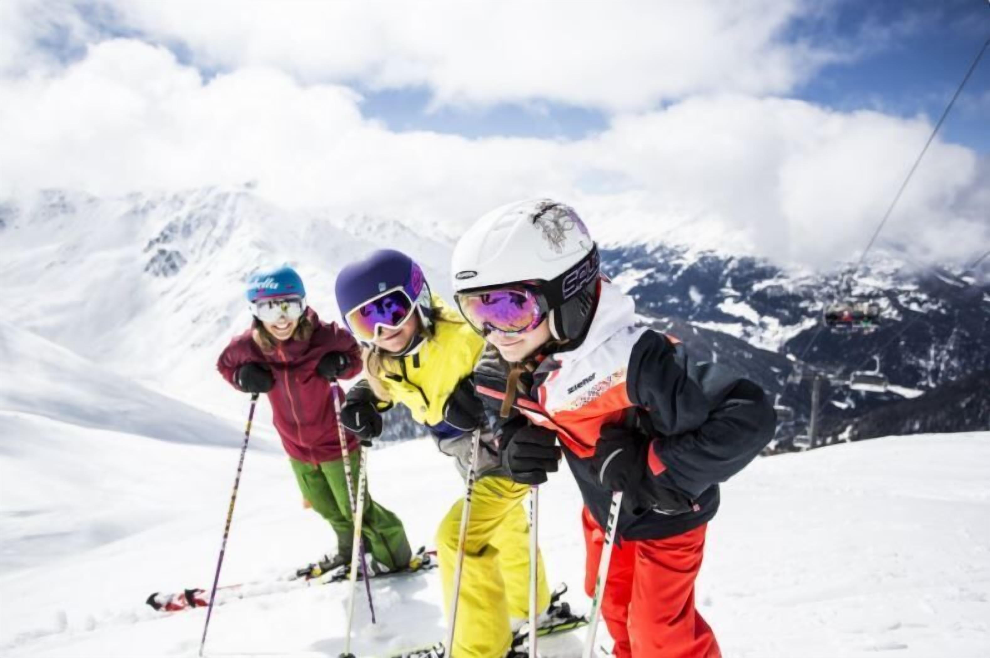 A group of skiers on a snowy mountain with a clear sky.