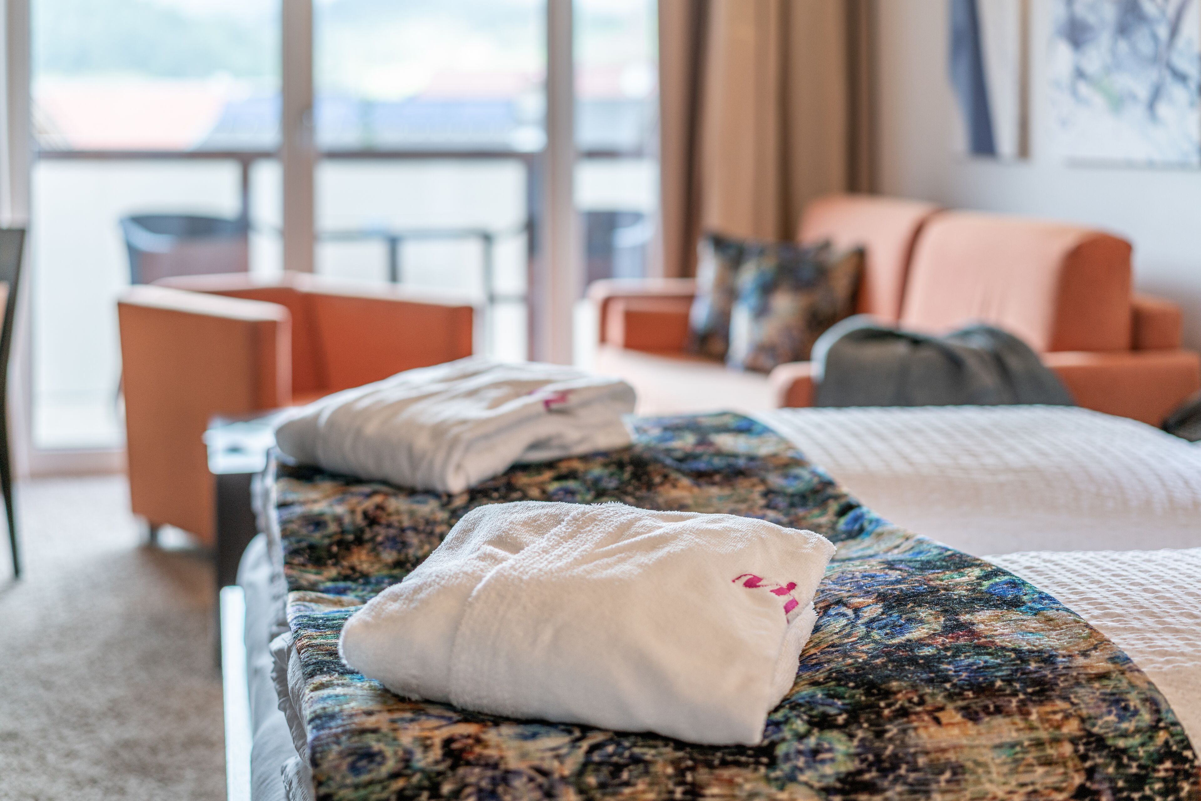 Una habitación de hotel con cama, sofá y vistas al exterior.