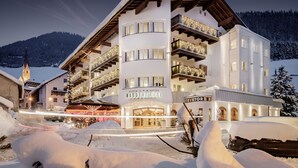 A multi-story hotel with balconies, a sign reading "ALPINS P A HOTEL NUDERHOF SUPERIOR", and a snowy mountain backdrop. - Hotel Naudererhof (Nauders)